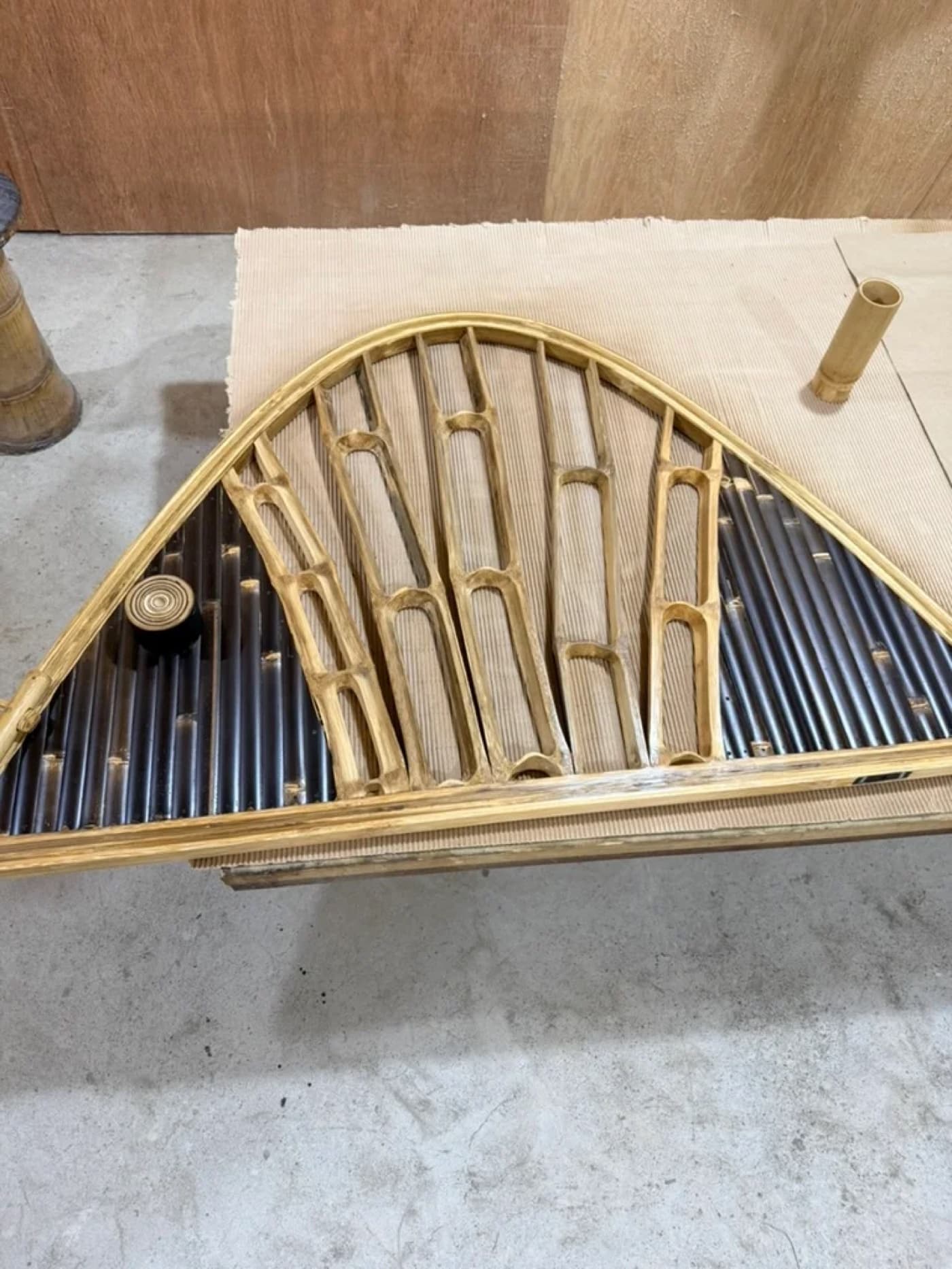 A woven bamboo gridshell lattice arch panel on the workshop bench