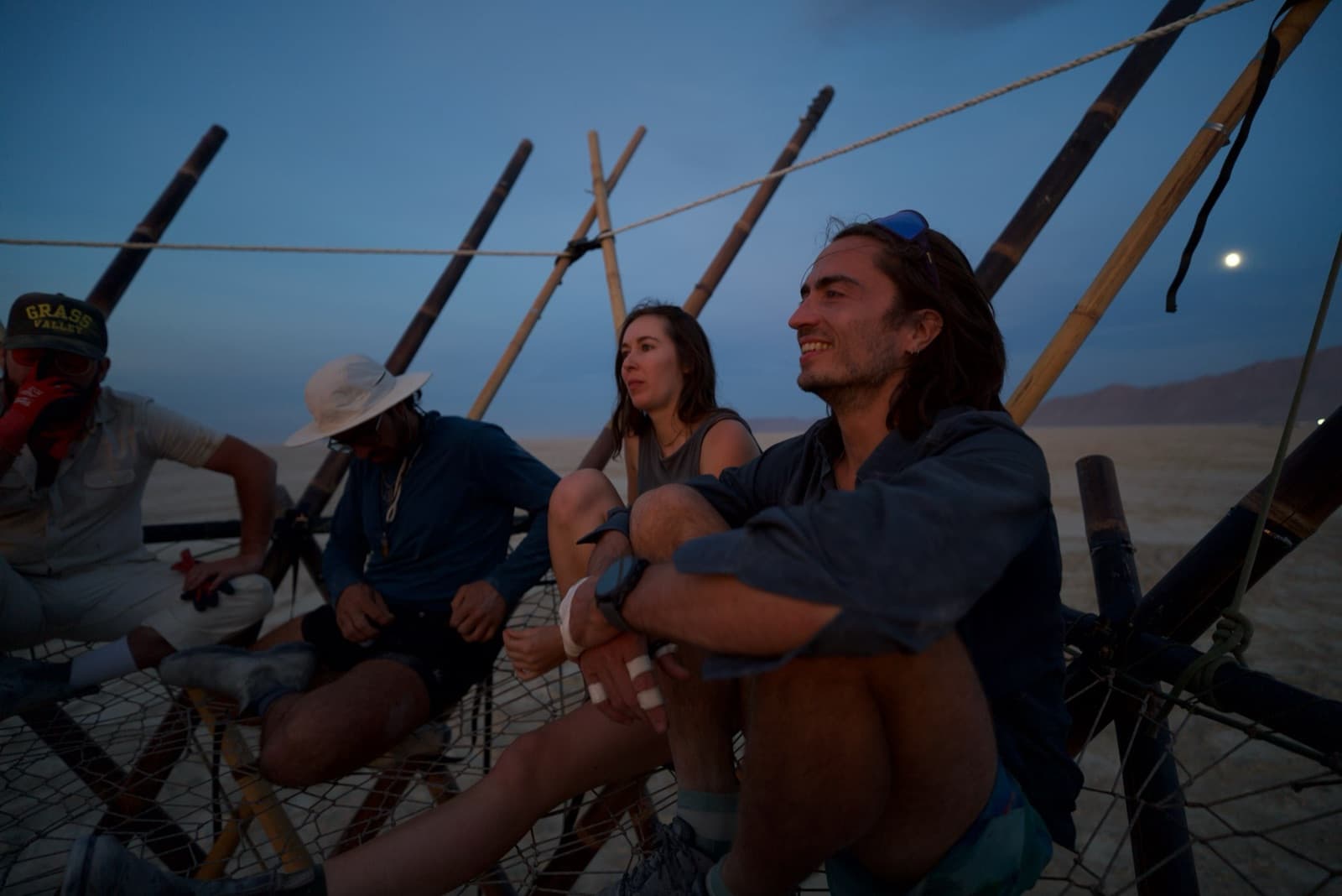 Crew resting together in the woven canopy nets high in the structure
