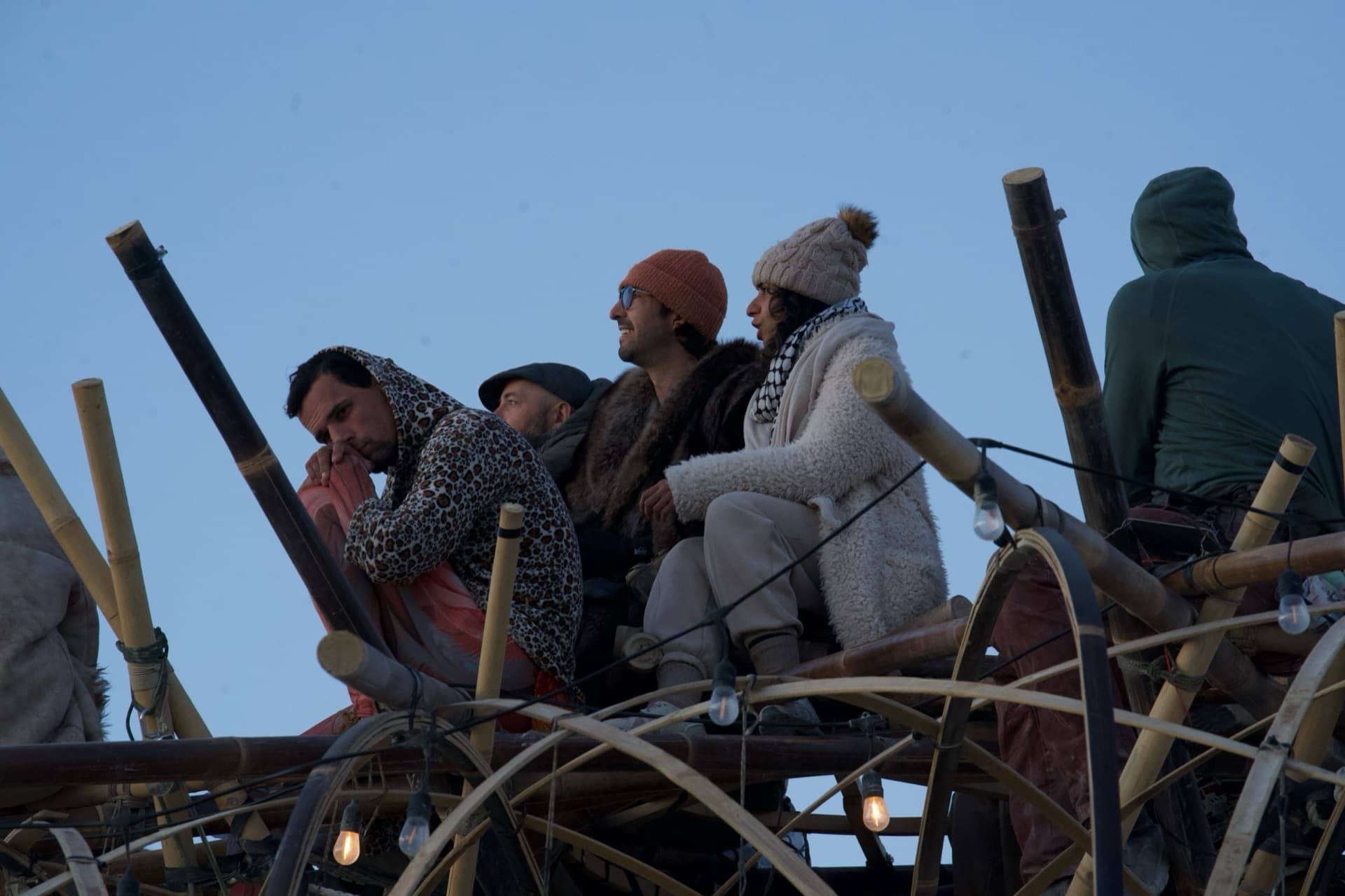 Volunteers smiling on the crown of the Resonance Tree at dusk on the playa